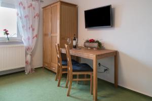 A television and/or entertainment centre at Pension Sleep-In Brettach