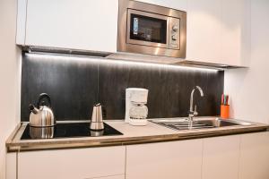uma cozinha com um lavatório e um micro-ondas em Rivacentro em Riva del Garda