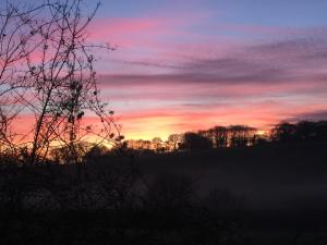 The sunrise or sunset as seen from the country house or nearby