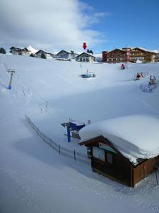 ein schneebedecktes Feld mit einem Gebäude im Schnee in der Unterkunft Haus Helga Obertauern in Obertauern