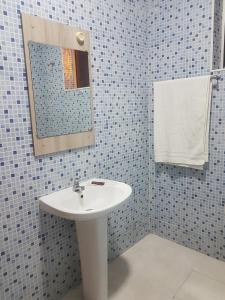 a bathroom with a sink and a mirror at Pensão Asa Branca in Assomada