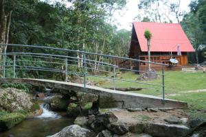 a bridge over a stream in front of a cabin at Cabana da Imperatriz in Santo Amaro da Imperatriz