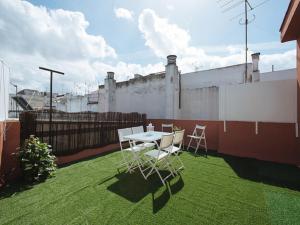 eine Terrasse mit einem Tisch und Stühlen auf dem Rasen in der Unterkunft Divi Apartments Martínez Montañes in Sevilla