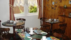 a dining room with two tables and a window at Masslink Guest House in Horley