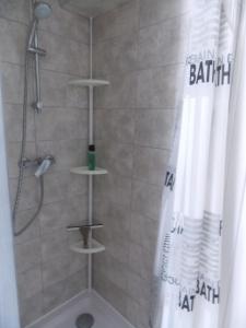 La salle de bains est pourvue d'une douche avec rideau de douche. dans l'établissement Cosy kaz, à Bormes-les-Mimosas