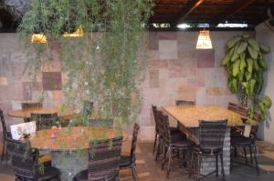 a restaurant with tables and chairs and bananas hanging from a wall at Pousada Cavalo Marinho in Pipa