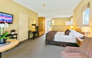 een hotelkamer met een bed, een bureau en een bank bij Wallaceville Motor Lodge in Upper Hutt