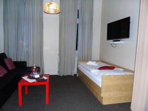 a small hotel room with a bed and a table at Landhaus Irmgard in Braunlage