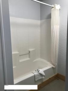 y baño blanco con bañera y ducha. en Arrowhead Point Lodge & Campground en Shay