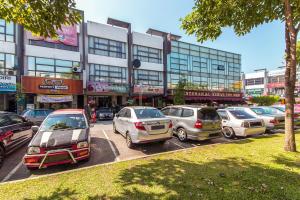 um grupo de carros estacionados num parque de estacionamento em frente a um edifício em De Elements Business Hotel KL em Kuala Lumpur