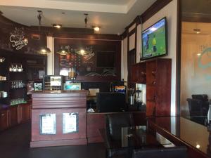 a restaurant with a bar with a tv on the wall at Seasons Riverside Hotel in Vientiane