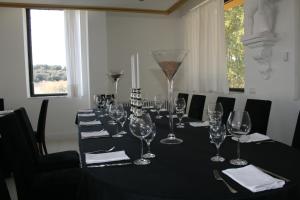 una larga mesa negra con copas de vino. en Mirador del Ermitage, en La Bañeza