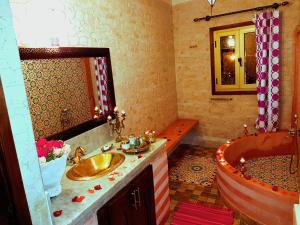 Un baño con bañera, lavabo y espejo. en Riad Konouz, en Marrakech 105 fotos más
