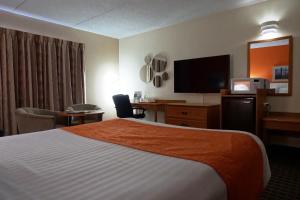 a hotel room with a bed and a flat screen tv at Howard Johnson by Wyndham Tillsonburg in Tillsonburg +4 photos