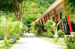 a walkway next to a house with trees and a building at Chongkhao Resort- SHA Certified in Phi Phi Islands