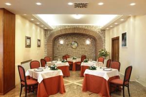 a dining room with tables and chairs and a brick wall at Villa Luisa in Todi