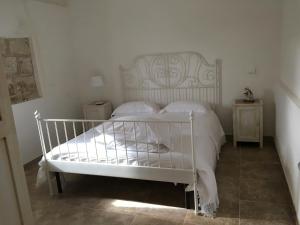 białe łóżko z białą pościelą i poduszkami w sypialni w obiekcie Masseria 25 Anni w mieście Laterza