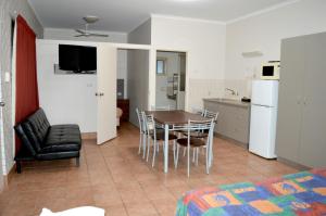 a kitchen and dining room with a table and chairs at Mid City Motor Inn in Gladstone