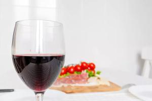 un verre de vin rouge à côté d'une assiette de viande dans l'établissement Nobile Casa, à Rome