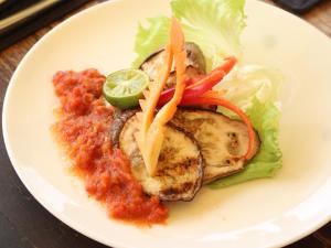a plate of food with chicken with lettuce and sauce at Jeeva Beloam Beach Camp in Tanjung Ringgit