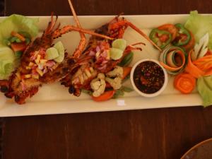 a plate of food with lobster and vegetables on a table at Jeeva Beloam Beach Camp in Tanjung Ringgit