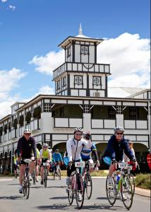 a group of people riding bikes down a street in front of a building at Freedom Lifestyle Parks Goondiwindi in Goondiwindi