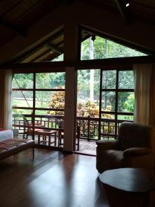 uma sala de estar com janelas grandes e um sofá em The Country House em Senggigi