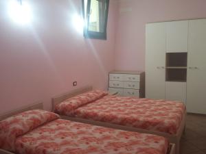 a bedroom with two beds and a dresser at Mare Dune Laghetto in Torre Dei Corsari