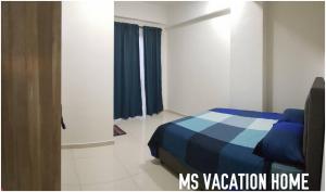 ein Schlafzimmer mit einem blauen und weißen Bett in einem Zimmer in der Unterkunft MS Vacation Home (Muslim Homestay) in Cameron Highlands