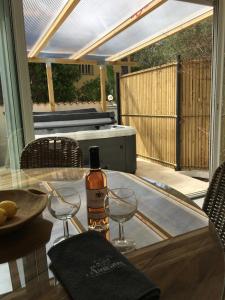 a bottle of wine sitting on a table with two wine glasses at Villa L'Amiraute in Agde