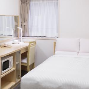 um quarto com uma cama e uma secretária com um computador em HOTEL MYSTAYS Higashi Ikebukuro em Tóquio