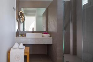 a bathroom with a sink and a shower at Poseidon of Paros Hotel & Spa in Chrissi Akti