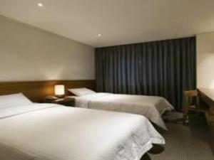 Postel nebo postele na pokoji v ubytování Busan Tourist Hotel