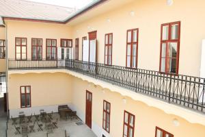 Vista anterior de un edificio con mesas y sillas en Promenade Panzió, en Miskolc