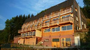 - un grand bâtiment avec des balcons sur le côté dans l'établissement Naturessime Eco Village&Spa, à Cheylade