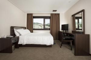 Postel nebo postele na pokoji v ubytování Busan Tourist Hotel