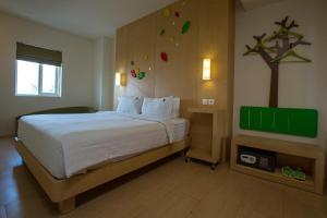 Postel nebo postele na pokoji v ubytování Ascent Hotel & Cafe Malang