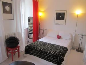 a bedroom with a bed and a red curtain at La Maison de Natasha in Castillon-en-Couserans