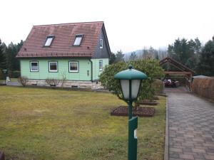 ein grünes Haus mit Straßenbeleuchtung davor in der Unterkunft Ferienhaus Schrammsteinblick in Bad Schandau
