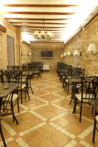 comedor con mesas y sillas y TV en Hotel Arabia, en Albarracín