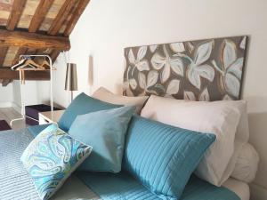 łóżko z biało-niebieskimi poduszkami w pokoju w obiekcie La Colombaia Nel Castello w mieście Bracciano