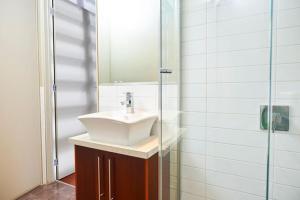 a bathroom with a sink and a glass shower at No.6 - Luxury Private Haven in the Heart of Bright in Bright