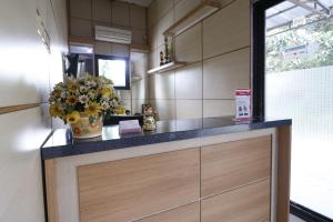 a kitchen with a counter with a vase of flowers at RedDoorz Plus near Undip Tembalang in Semarang