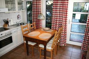 フーズムにある"Haus Husum"のキッチン(木製テーブル、椅子、シンク付)