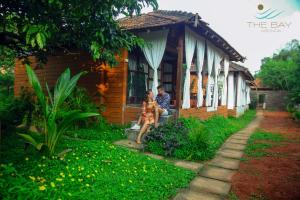 a man and a woman sitting outside of a house at The Bay Agonda in Agonda