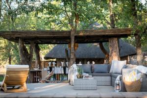 a wooden pergola with a couch and chairs on a patio at Chacma Bush Camp in Balule Game Reserve