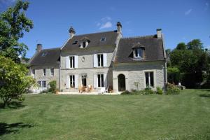 une grande maison en pierre avec une grande cour dans l'établissement L'eau vive, à Amblie