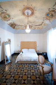 1 dormitorio con 1 cama con techo artesonado en Sveva rooms, en Noto