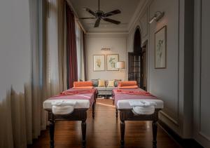 A bed or beds in a room at The Strand, Yangon
