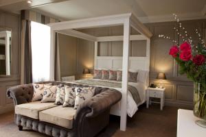 a bedroom with a canopy bed and a couch at Vanbrugh House Hotel in Oxford